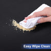 A hand wipes a light-colored cloth across a dark surface, leaving a residue of yellow powder.