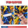 A close-up of a white pom pom with a handle wrapped in shiny blue and gold foil, shown being held by a hand.