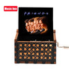 A carved wooden music box featuring a display of friends silhouettes on a dark background.