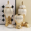 A set of handcrafted ceramic decorative vases in gold and white with ribbed textures.