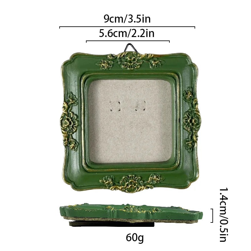 A vintage baroque resin picture frame in olive green with gold accents, shown with a separate backing piece.