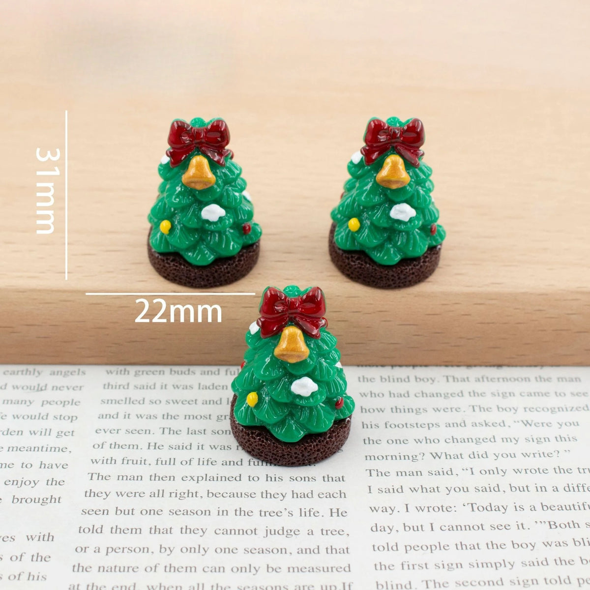 A set of festive Christmas resin decor featuring small green trees with yellow ornaments and red bows.