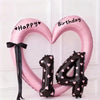 Pink foil heart balloon decoration shaped like the number 4 with happy and birthday text