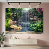 A large framed painting depicting a lush garden scene with a waterfall cascading over rocks and greenery.