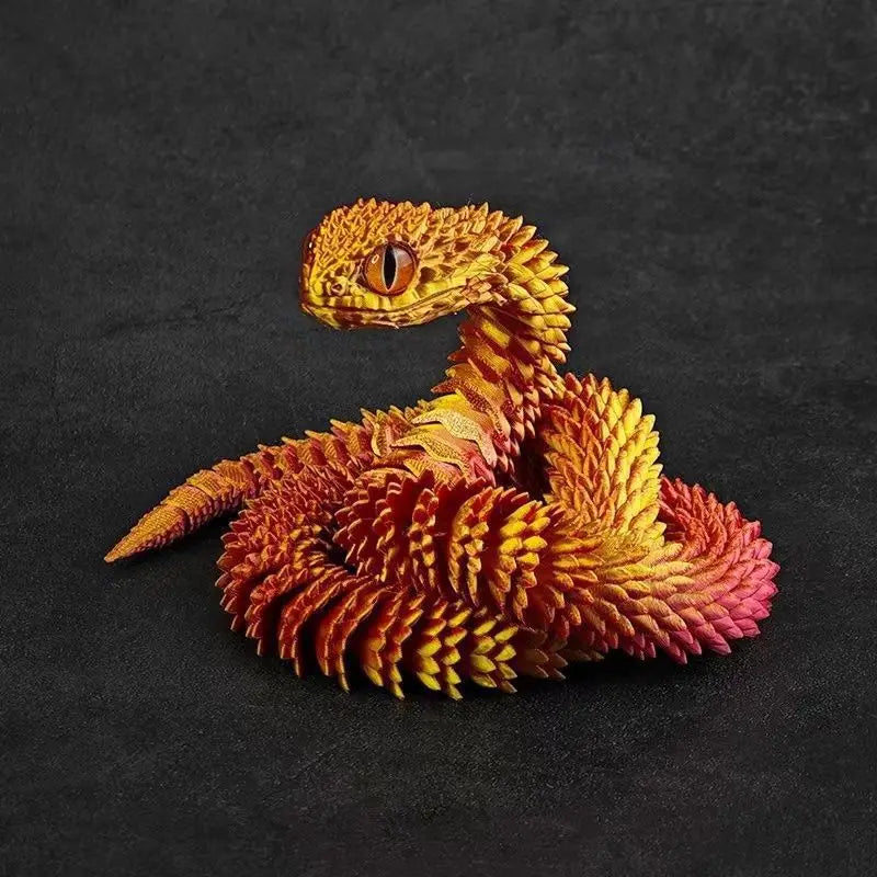 A detailed, orange and yellow 3D printed rotatable snake art model resting on a dark surface.