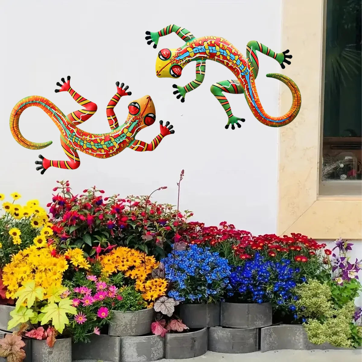Handcrafted metal gecko wall art featuring colorful, vibrant geckos displayed above a garden bed.