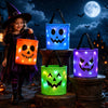 A young girl stands next to three glowing LED illuminated Halloween trick-or-treat bags shaped like jack-o'-lanterns against 