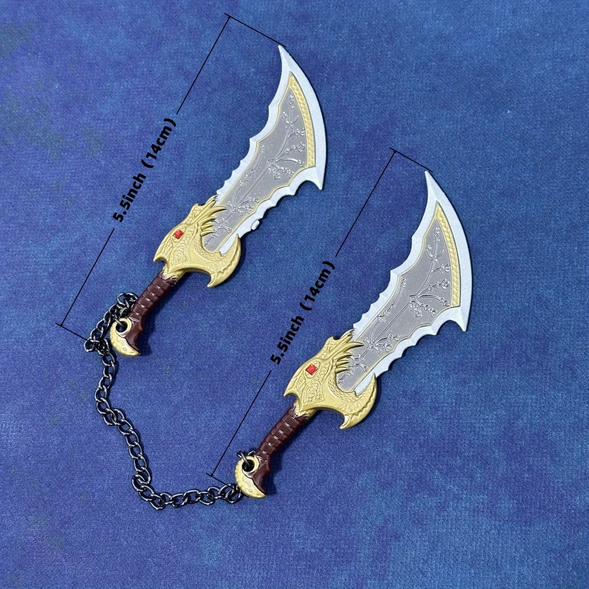 A pair of miniature God of War Kratos Katana collectible swords with silver blades and gold hilts displayed on a blue backgro