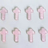 Eine Ansammlung von rosa Glitzerkristallkreuzdekorationen in einem Raster.