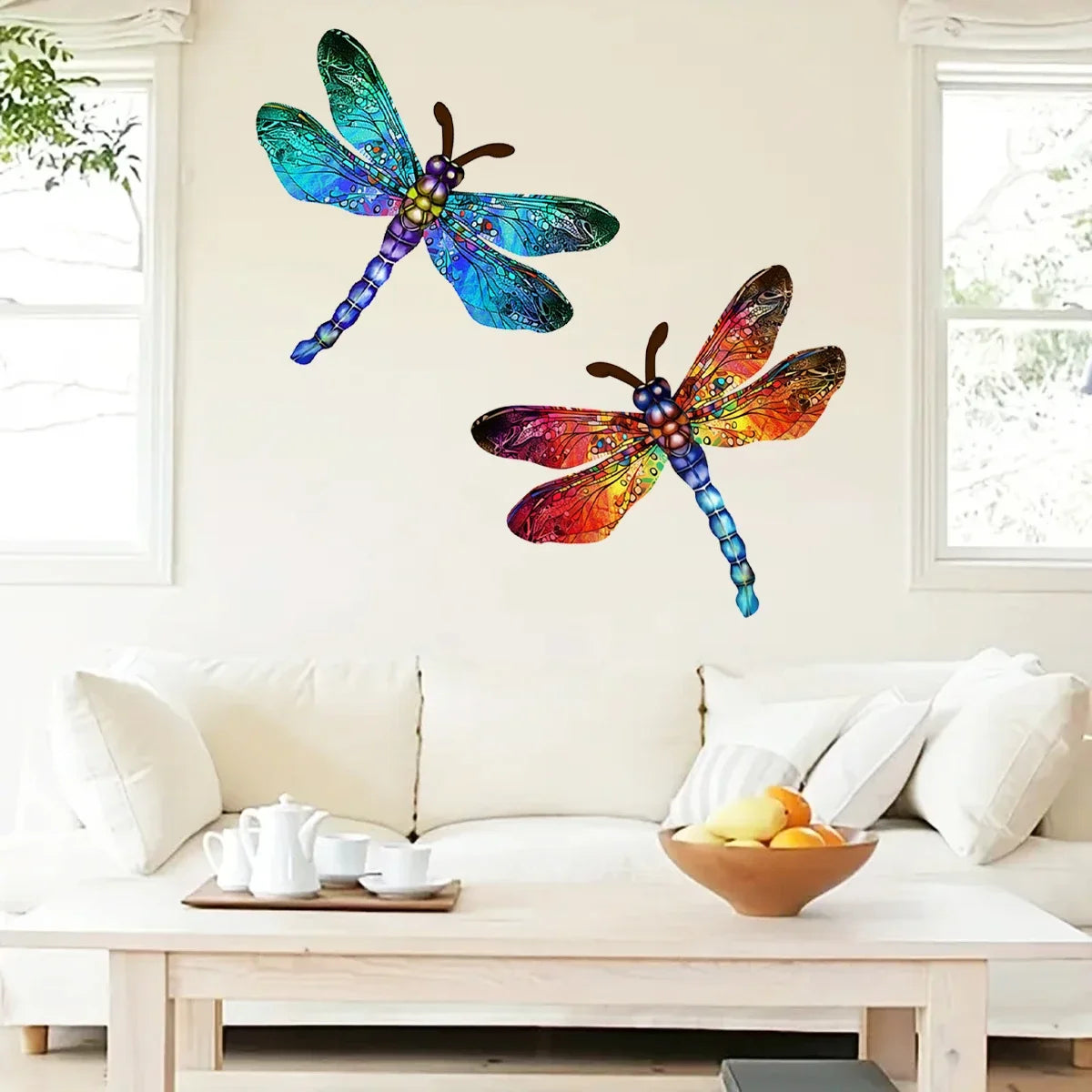 A vibrant blue and green dragonfly wall art sculpture is displayed above a light-colored sofa.