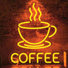 A bright yellow neon sign shaped like a steaming cup of coffee mounted on a brick wall.
