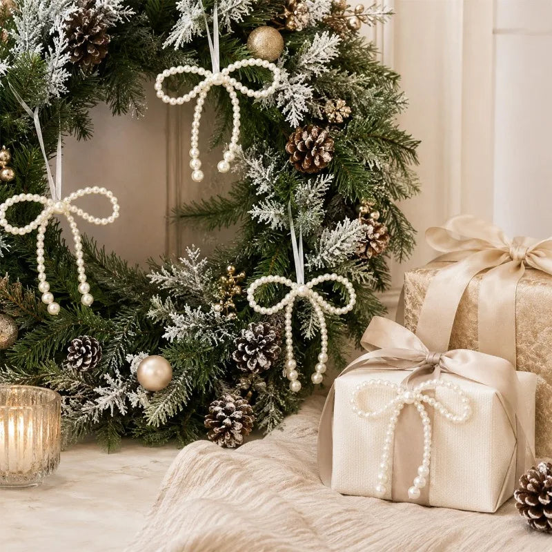 A festive wreath decorated with pine branches, evergreen foliage, pinecones, and pearl bow ornaments.