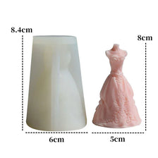 A pink silicone mold shaped like a wedding dress, used for making candles or chocolate.