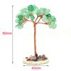Natural crystal money tree decor featuring green translucent crystals on a copper wire branch with a stone base