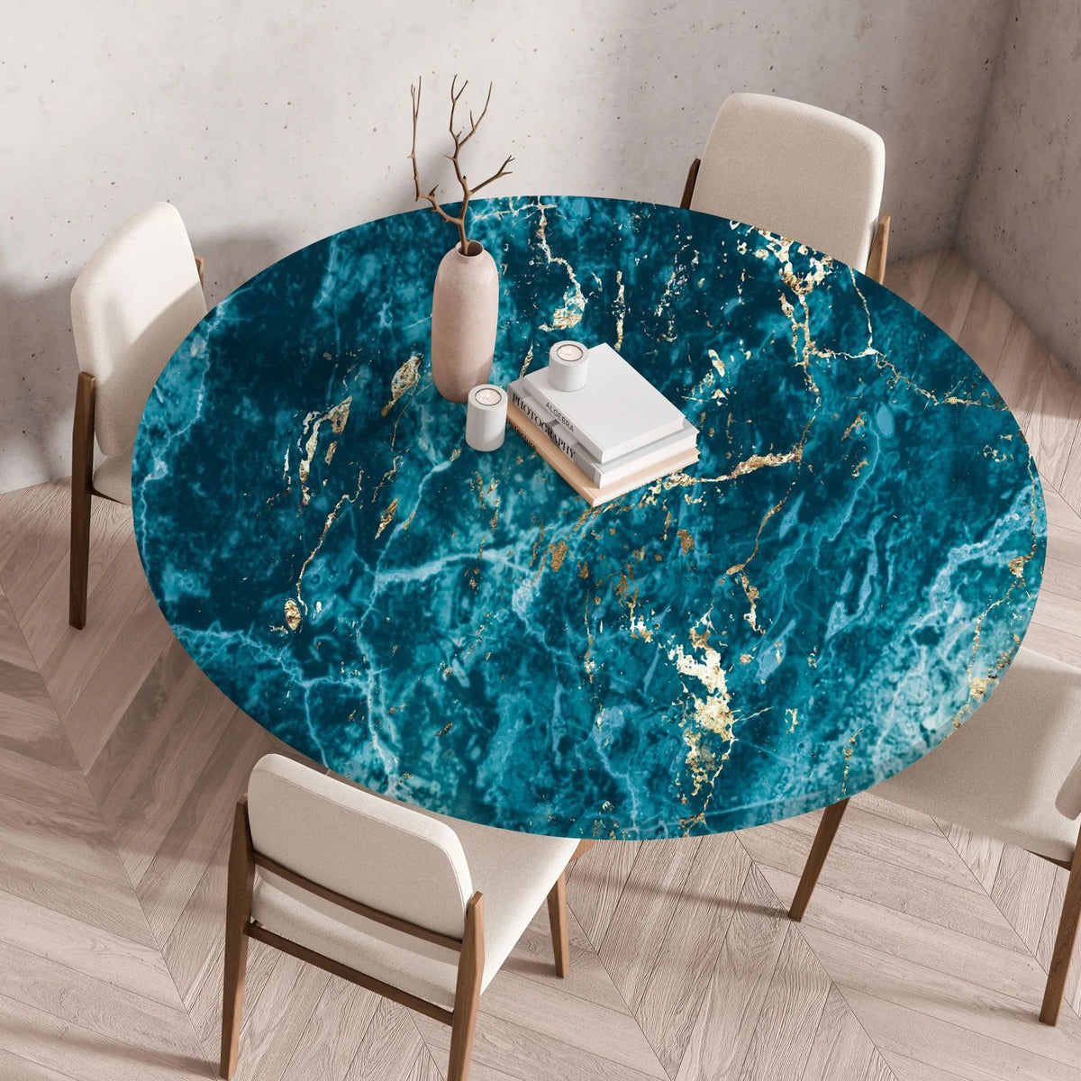 A round table set with a teal marble print tablecloth featuring gold veining and white modern chairs.