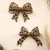 A leopard print bow-shaped wall mounted storage rack made of natural wood.