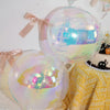 A close-up of iridescent holographic round foil balloons in pink and blue tones, used for party decor.
