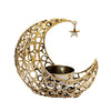 A golden crescent moon candle holder with a star charm hanging from the edge.