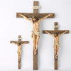 A wooden cross with a resin figure of Jesus Christ crucified, used for home and office decor.