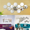 A collection of 12 self-adhesive hexagon mirror stickers decorating a light yellow brick wall.