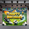 A vibrant soccer field backdrop for a birthday celebration featuring a large football, trophies, and festive lights.