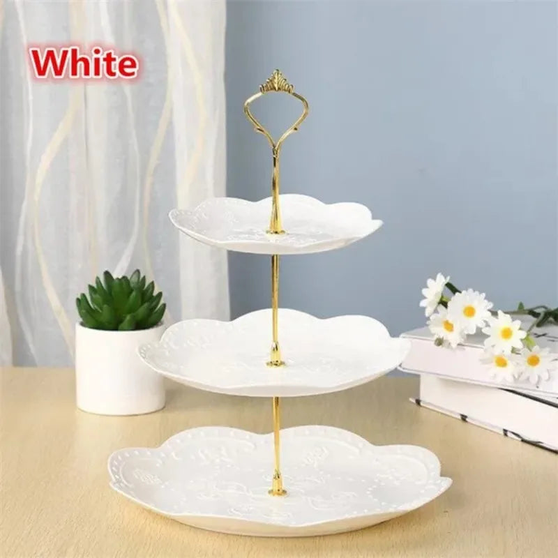 A white, three-tier detachable cake stand with gold accents for serving desserts and fruit.