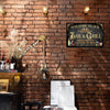 Vintage-Bier-Schild aus Metall als Wanddeko mit Goldschrift vor dunklem Hintergrund an einer Ziegelwand.