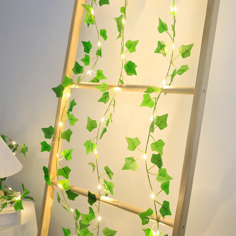 A vertical display of green artificial ivy vine string lights against a light background.