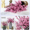 A bouquet of pink cherry blossoms and gypsophila artificial flowers displayed in a vase.