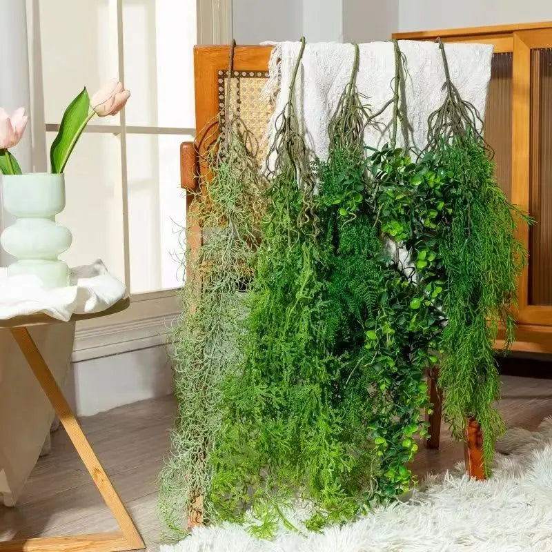Artificial hanging ivy vine with green leaves draped over a wooden cabinet