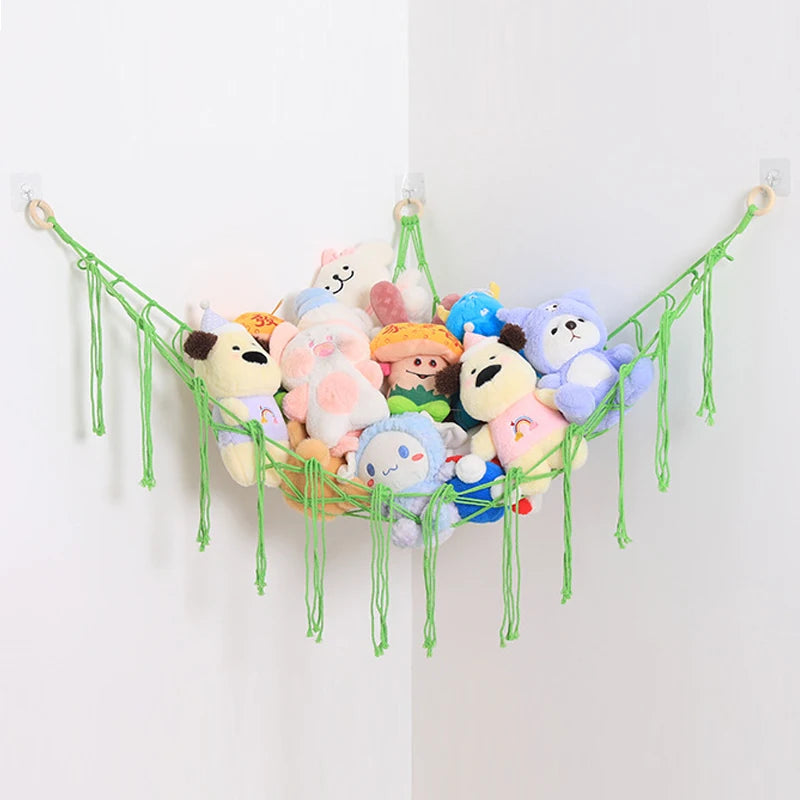 A colorful cotton hammock display featuring various stuffed animals and plushies hanging on a white wall.
