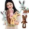 A woman holds several plush rabbit toys in various colors including blue, brown, and pink.