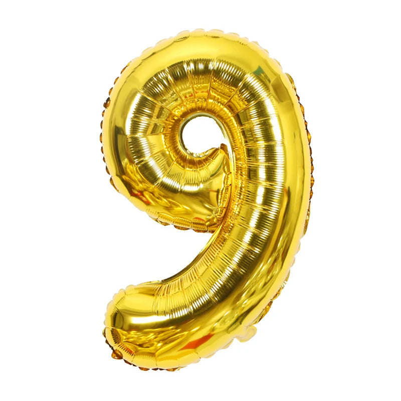 A shiny gold foil number balloon shaped like the number nine.