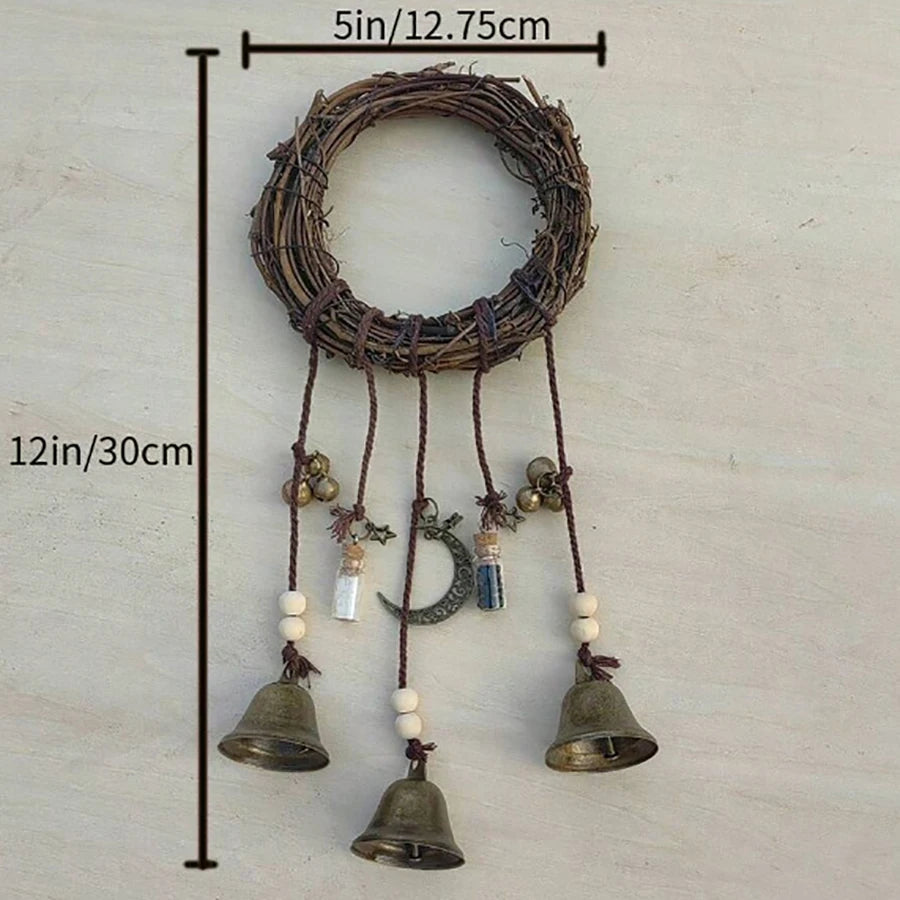 A rustic wreath with hanging bells and a crescent moon decoration on a wooden background.