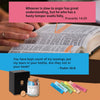 A glass jar filled with tears and a book featuring Bible verses, set on a wooden surface.