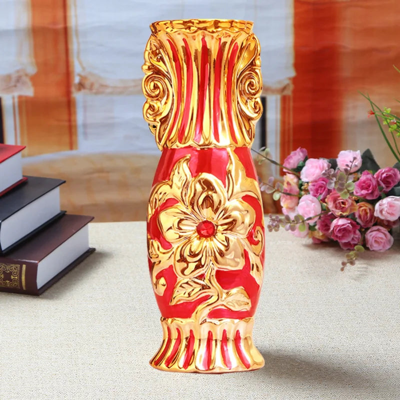A gold-plated ceramic tabletop vase with red and gold floral patterns.