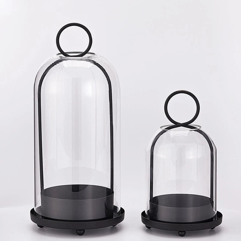 A set of antique brass metal candle holders with glass domes, shown in a vertical arrangement.