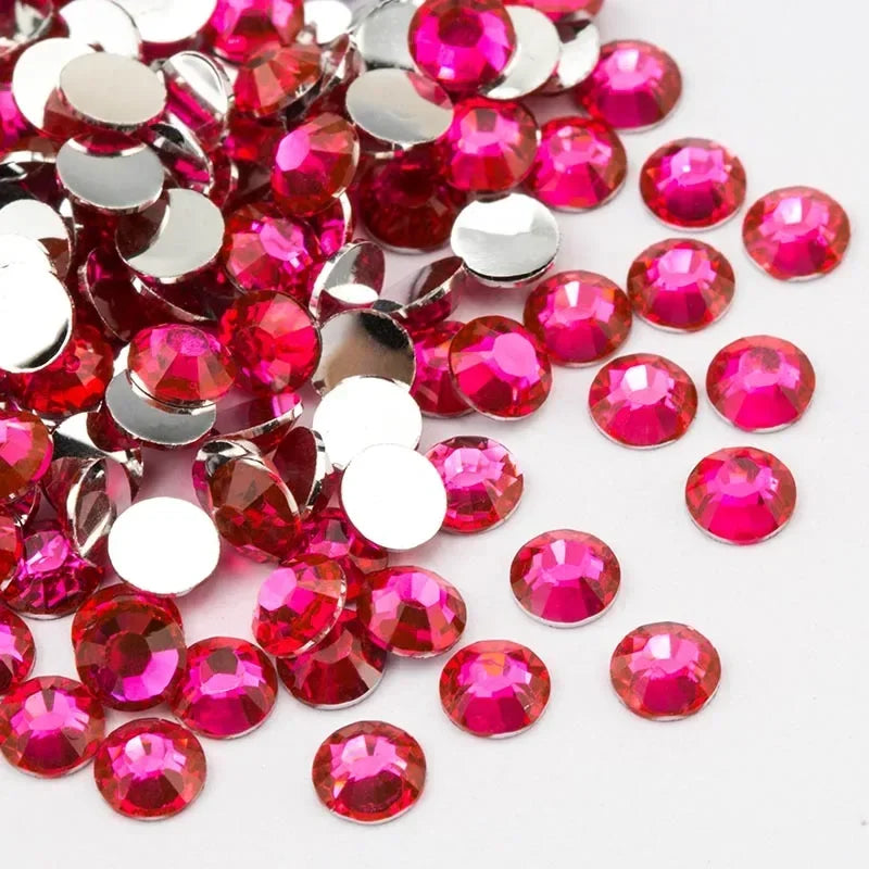 A pile of round flatback resin rhinestones in various shades of pink and red.