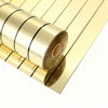 Rolls of gold self-adhesive mirror effect wallpaper stacked diagonally on a white background.