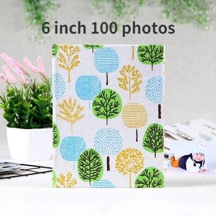 A square photo album cover featuring a pattern of stylized green and yellow trees on a light background.