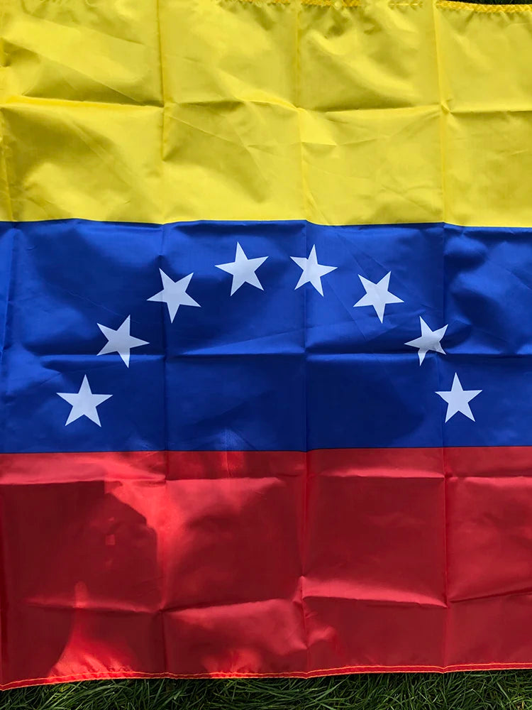 A folded Venezuelan national flag featuring yellow, blue, and red horizontal stripes with white stars.