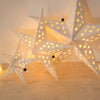A geometric white star pendant light decor with gold stars and warm glow.