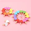 A circular arrangement of small wooden heart clips in various pastel colors like pink, yellow, and green.