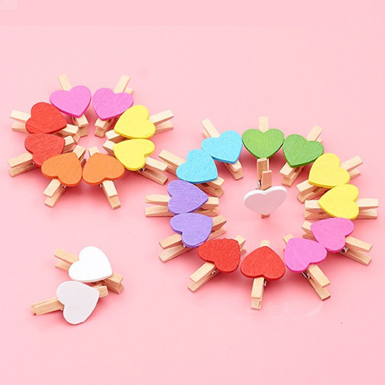 A circular arrangement of small wooden heart clips in various pastel colors like pink, yellow, and green.
