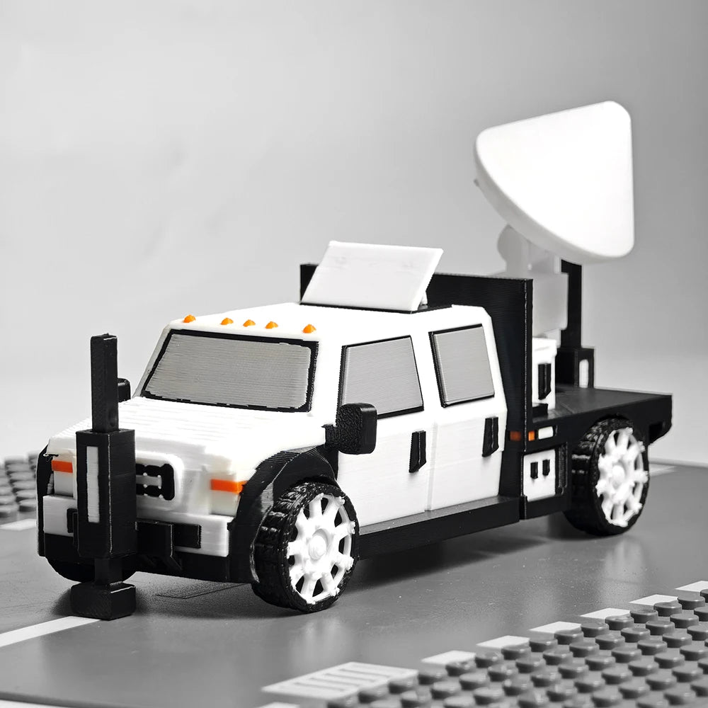 A black and white 3D printed display model of a vehicle, resembling an interceptor, with a large dome on top.