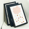 A set of three black picture frames with acrylic fronts displaying a pink cloud and scattered colored dots.