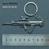 A silver alloy gun model miniature keychain with a realistic finish, shown next to a ruler.