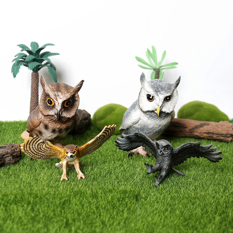 A figurine set featuring a realistic owl, vulture, and bald eagle perched on green grass with small plants.