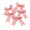 A set of pink satin ribbon bows used for gifts and DIY crafts.