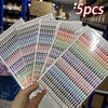 A hand holds a pack of glitter gem stick-on facial tattoos featuring various colorful gems.